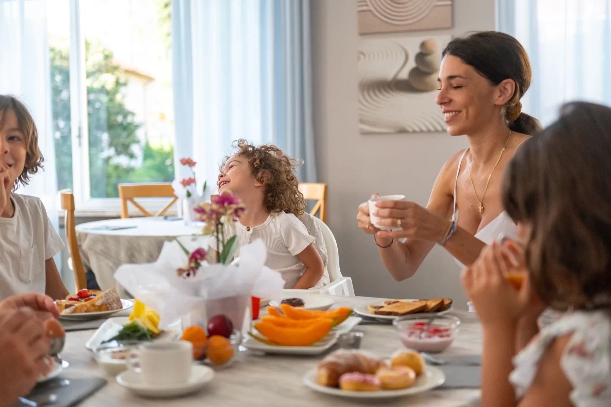 A family enjoys breakfast together at a table with various dishes.